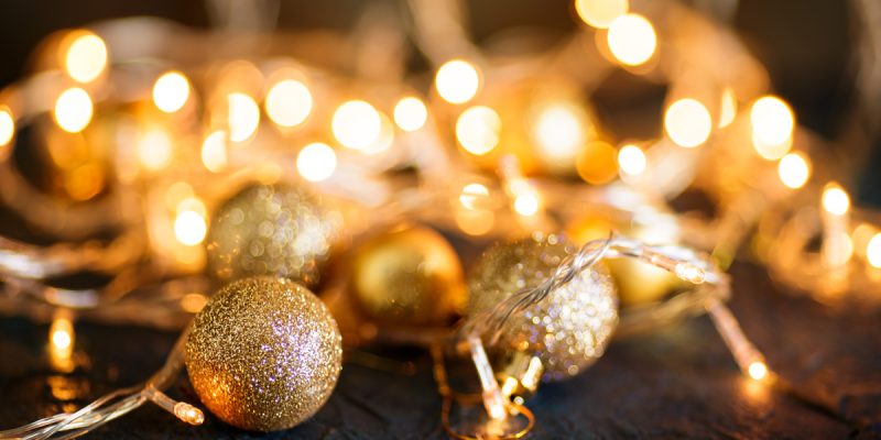 Goldene Weihnachtskugeln und Lichter als stimmungsvolles Symbol für das Adventscafé