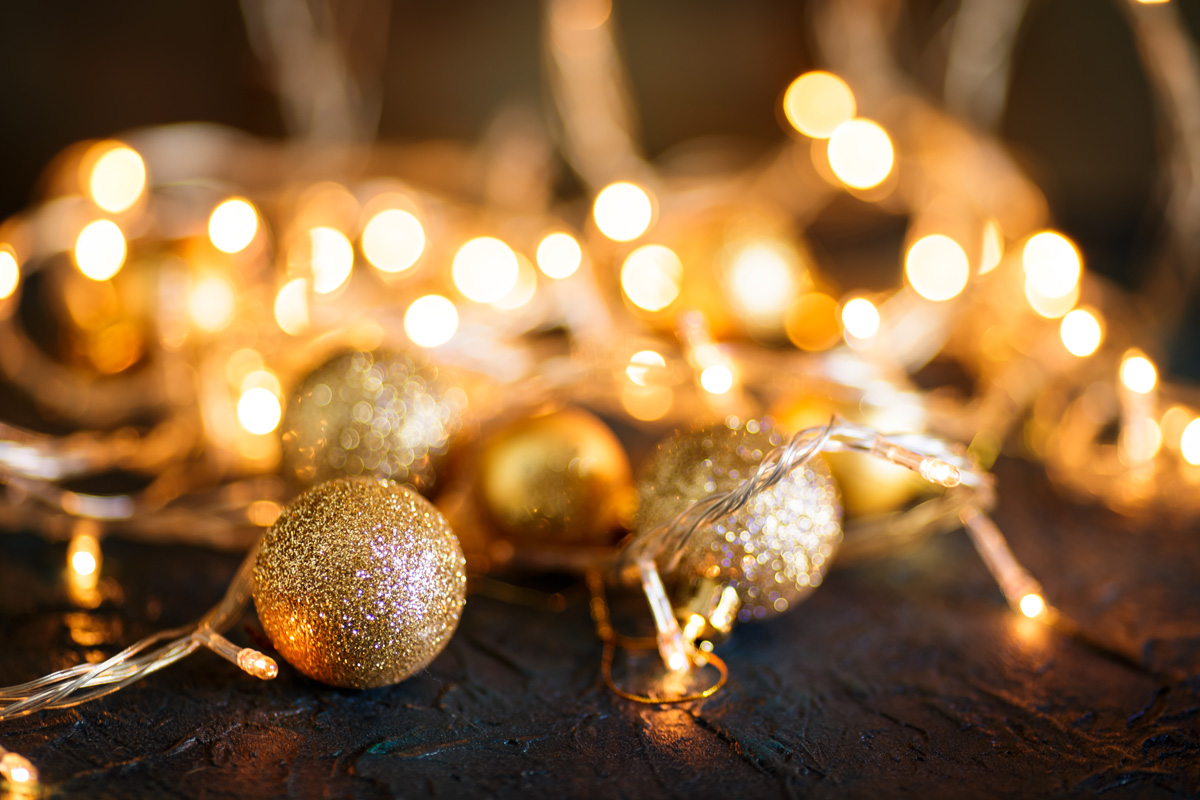 Goldene Weihnachtskugeln und Lichter als stimmungsvolles Symbol für das Adventscafé